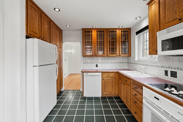 99 Wenonah Dr, Pontiac, MI 48341 - kitchen featuring white appliances, a sink, glass insert cabinets, brown cabinets, and tasteful backsplash