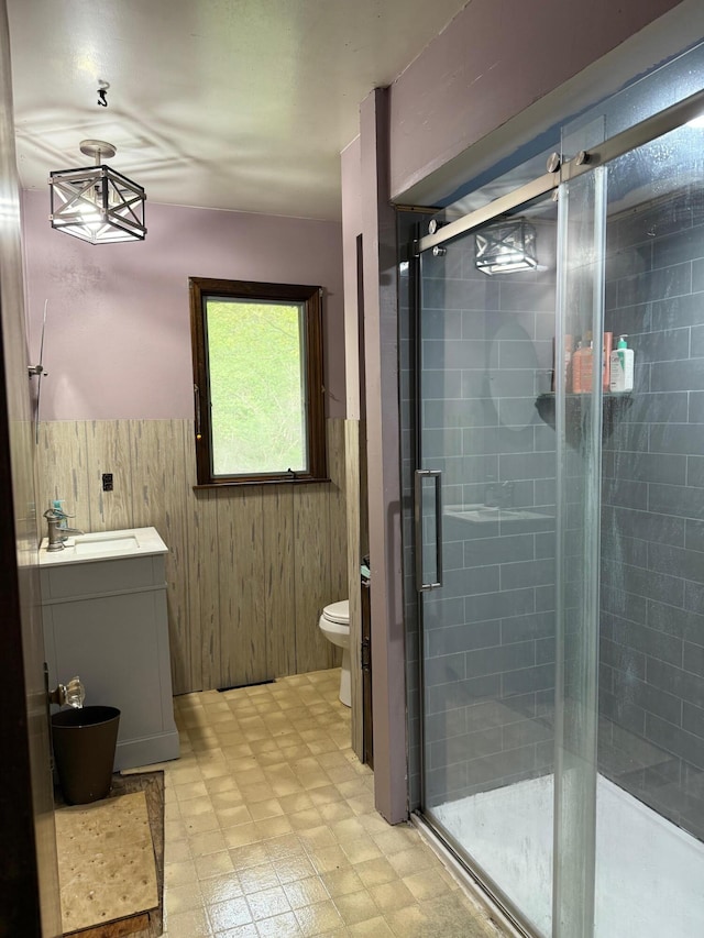 3104 Chippewa Hwy, Manistee, MI 49660 - full bathroom with tile patterned floors, toilet, wainscoting, a shower stall, and vanity