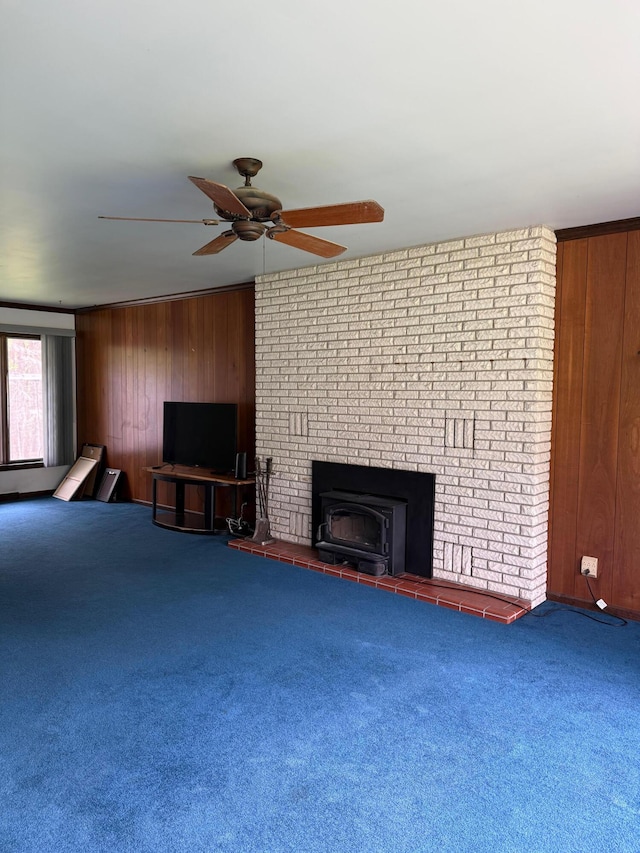3104 Chippewa Hwy, Manistee, MI 49660 - unfurnished living room with carpet, wood walls, a ceiling fan, and a brick fireplace
