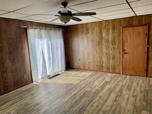 612 N Prospect St, Sturgis, MI 49091 - spare room with a ceiling fan, healthy amount of natural light, wooden walls, wood finished floors, and baseboards