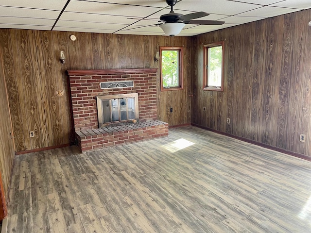 612 N Prospect St, Sturgis, MI 49091 - unfurnished living room featuring baseboards, a ceiling fan, wood finished floors, and wooden walls