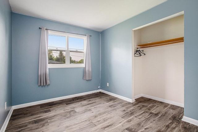 1246 Chalmers Dr, Battle Creek, MI 49015 - unfurnished bedroom featuring wood finished floors, a closet, and baseboards