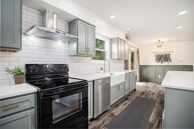 1246 Chalmers Dr, Battle Creek, MI 49015 - kitchen with black range with electric stovetop, wall chimney exhaust hood, dishwasher, gray cabinetry, and a wainscoted wall