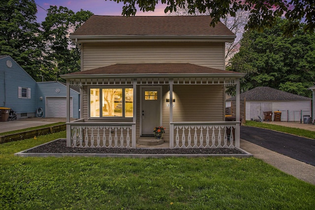 329 N Liberty St, Marshall, MI 49068 - view of front of home featuring a porch, an outdoor structure, a garage, and a front yard