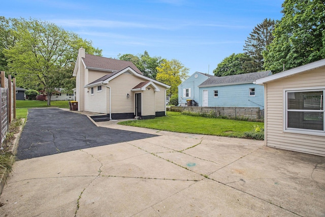 329 N Liberty St, Marshall, MI 49068 - rear view of property featuring asphalt driveway and a patio