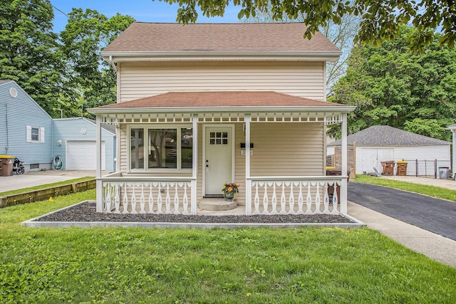 329 N Liberty St, Marshall, MI 49068 - view of front of house with a porch, an outdoor structure, a detached garage, and a front yard