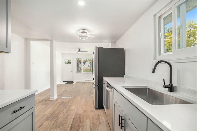 329 N Liberty St, Marshall, MI 49068 - kitchen featuring a sink, stainless steel appliances, light countertops, light wood-style flooring, and a ceiling fan