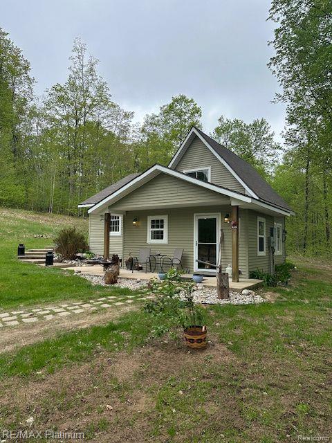 3624 Windy Hollow Rd NW, Rapid City, MI 49676 - bungalow-style house featuring a patio area