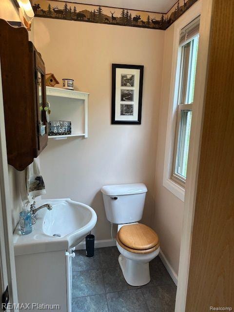 3624 Windy Hollow Rd NW, Rapid City, MI 49676 - bathroom with baseboards, toilet, and a sink