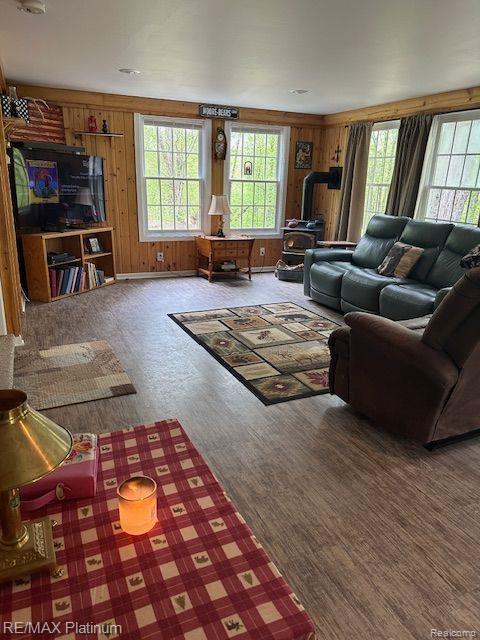 3624 Windy Hollow Rd NW, Rapid City, MI 49676 - living area featuring healthy amount of natural light, wood finished floors, and wooden walls