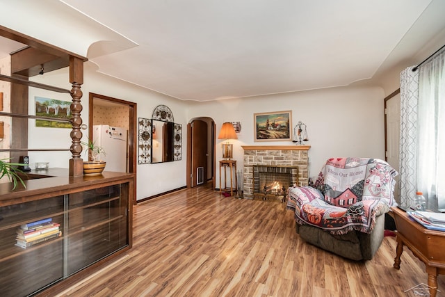 2430 S 4 Mile Rd, Kawkawlin, MI 48631 - living room with arched walkways, wood finished floors, and a stone fireplace