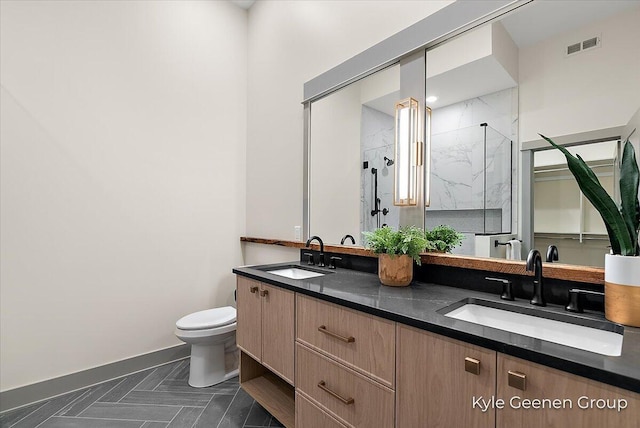 52 E 8th St Ste 210, Holland, MI 49423 - bathroom featuring a marble finish shower, toilet, double vanity, and baseboards