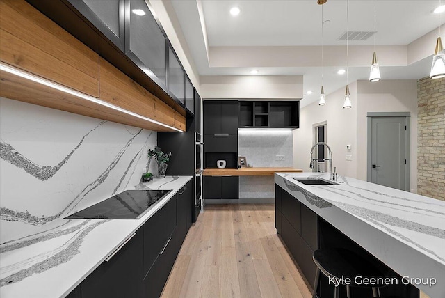 52 E 8th St Ste 210, Holland, MI 49423 - kitchen featuring dark cabinetry, a sink, light wood-type flooring, open shelves, and modern cabinets