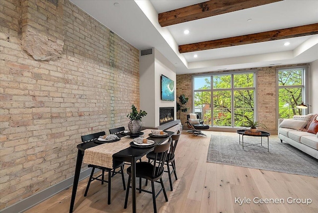 52 E 8th St Ste 210, Holland, MI 49423 - dining room with brick wall, plenty of natural light, beam ceiling, wood finished floors, and a glass covered fireplace