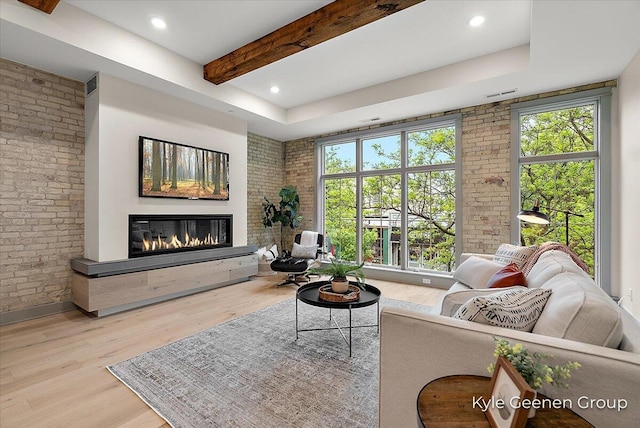 52 E 8th St Ste 210, Holland, MI 49423 - living area with a glass covered fireplace, wood finished floors, beamed ceiling, brick wall, and recessed lighting