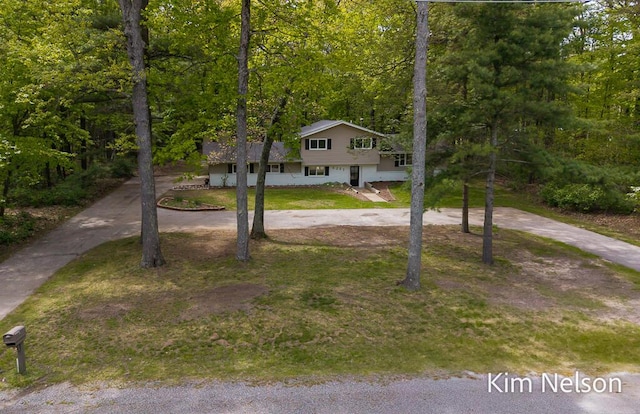 5203 Nestrom Rd, Whitehall, MI 49461 - view of front of house with a forest view and a front lawn