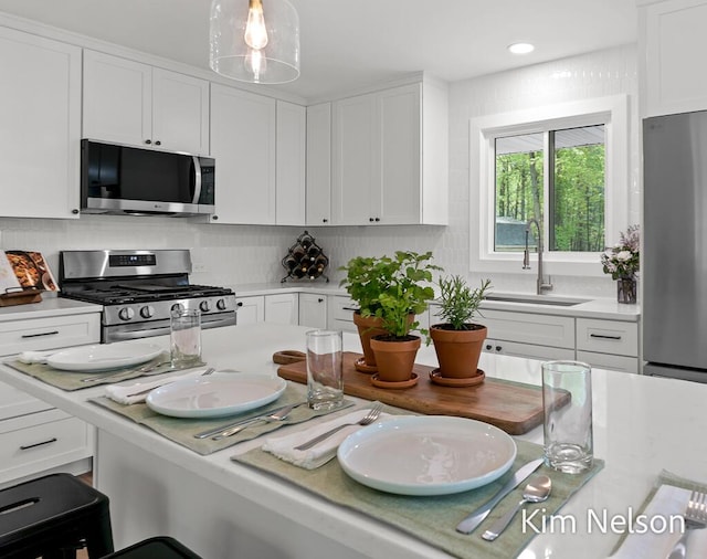 5203 Nestrom Rd, Whitehall, MI 49461 - kitchen with stainless steel appliances, a sink, light countertops, white cabinetry, and recessed lighting