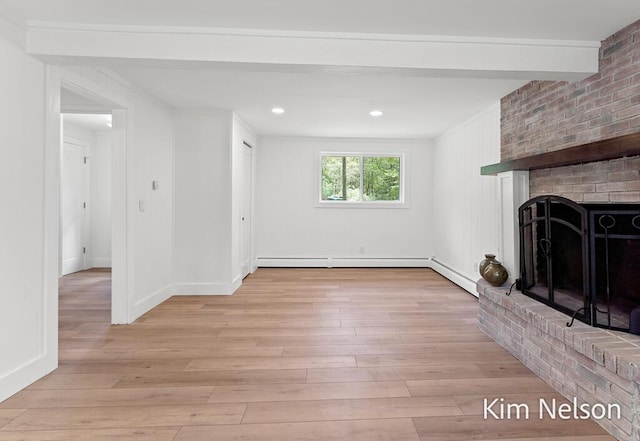 5203 Nestrom Rd, Whitehall, MI 49461 - unfurnished living room featuring a baseboard radiator, a fireplace, light wood-type flooring, crown molding, and baseboard heating
