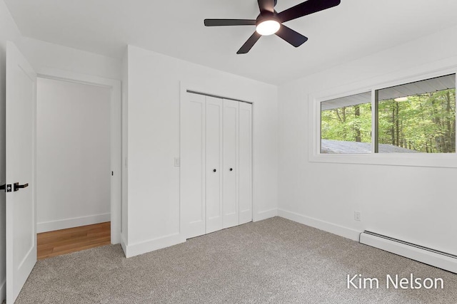 5203 Nestrom Rd, Whitehall, MI 49461 - unfurnished bedroom featuring carpet flooring, a baseboard radiator, a closet, baseboards, and a ceiling fan