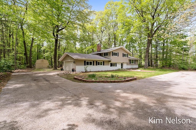 5203 Nestrom Rd, Whitehall, MI 49461 - tri-level home featuring a chimney, concrete driveway, and a garage
