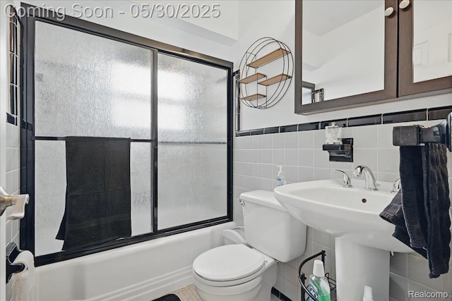 4412 Cooper Ave, Royal Oak, MI 48073 - full bathroom featuring tile walls, toilet, and bath / shower combo with glass door