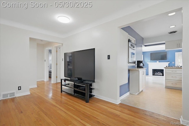 4412 Cooper Ave, Royal Oak, MI 48073 - living area with a brick fireplace, baseboards, and light wood-style floors