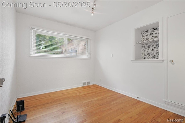 4412 Cooper Ave, Royal Oak, MI 48073 - spare room featuring light wood-type flooring, rail lighting, and baseboards