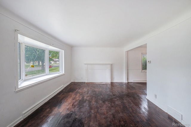 2952 Clement St, Flint, MI 48504 - empty room with plenty of natural light, wood finished floors, baseboard heating, and baseboards