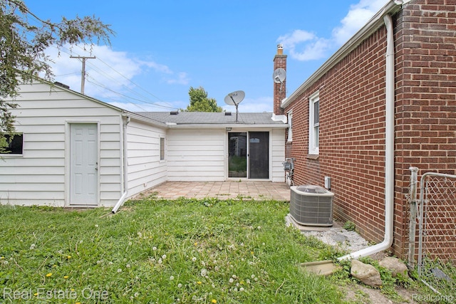 14620 Trenton Rd, Southgate, MI 48195 - rear view of house with a patio, central AC unit, a yard, brick siding, and a chimney
