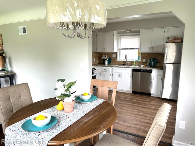 14620 Trenton Rd, Southgate, MI 48195 - kitchen featuring stainless steel appliances, a sink, a chandelier, decorative backsplash, and crown molding