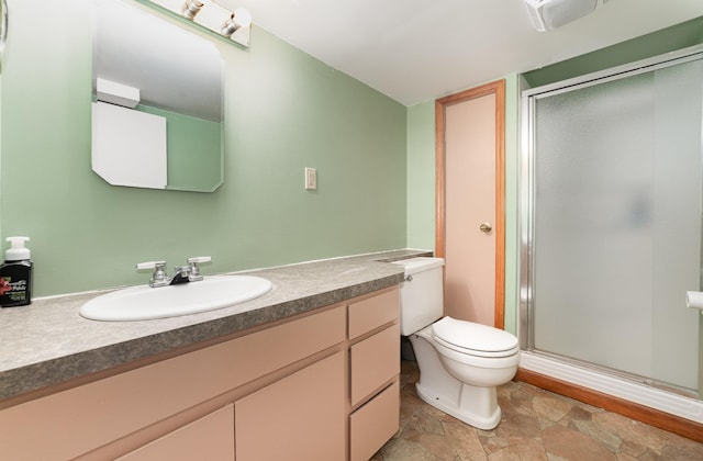 812 W Center, Alma, MI 48880 - bathroom featuring vanity, a stall shower, toilet, and stone finish flooring