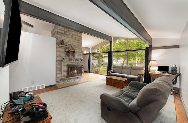 812 W Center, Alma, MI 48880 - living area featuring wood finished floors, a stone fireplace, baseboards, and a chandelier