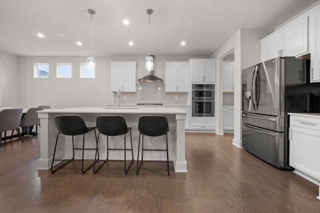 2610 Ironton Dr, Commerce Twp, MI 48382 - kitchen featuring wall chimney exhaust hood, stainless steel appliances, a kitchen breakfast bar, a sink, and dark wood-style flooring