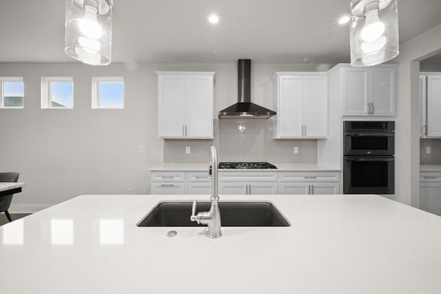 2610 Ironton Dr, Commerce Twp, MI 48382 - kitchen with wall chimney exhaust hood, double oven, a sink, light countertops, and gas cooktop