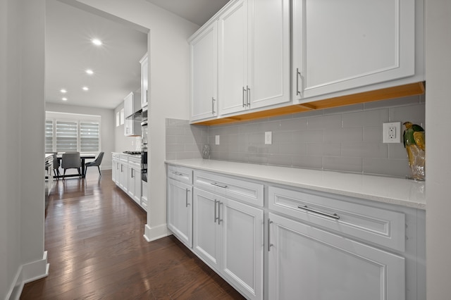 2610 Ironton Dr, Commerce Twp, MI 48382 - kitchen with white cabinetry, dark wood-style flooring, light countertops, recessed lighting, and backsplash