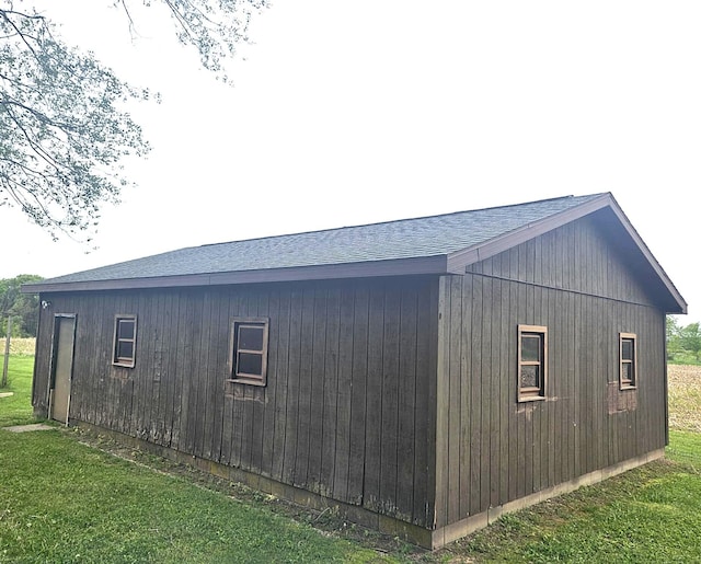 10122 Jones Rd, Bellevue, MI 49021 - view of side of property featuring a shingled roof and a lawn