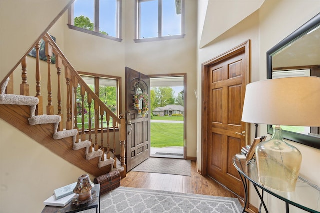 3172 Shadow Brook Ln, Pinckney, MI 48169 - foyer with wood-type flooring, stairway, a high ceiling, and baseboards