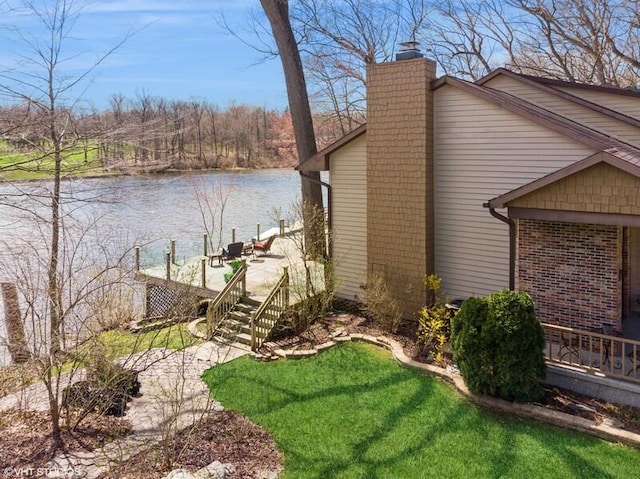 2942 White Oaks Ln, Buchanan, MI 49107 - view of side of property with a chimney, brick siding, a deck with water view, and a yard