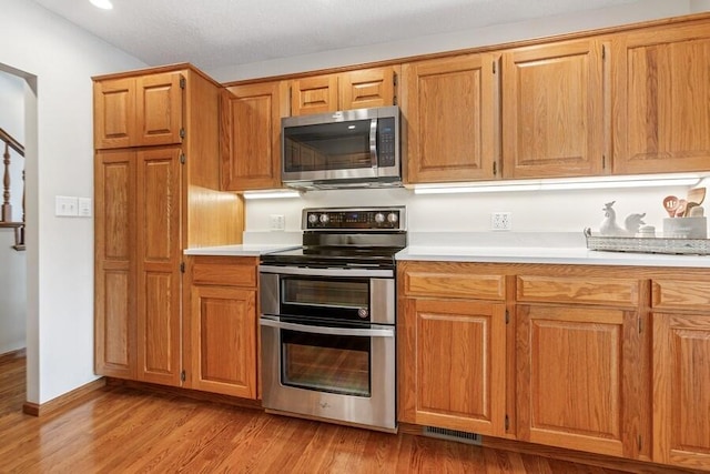 2942 White Oaks Ln, Buchanan, MI 49107 - kitchen featuring stainless steel appliances, light countertops, light wood-style flooring, brown cabinets, and recessed lighting
