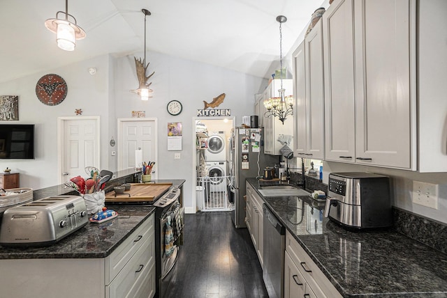 3921 Wildwood Ave, Bitely, MI 49309 - kitchen featuring stacked washer / dryer, stainless steel appliances, a sink, dark wood-style flooring, and lofted ceiling