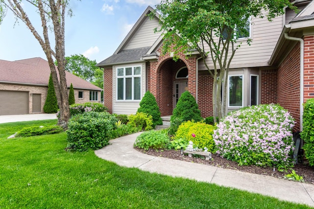 7009 Suncrest Dr, Saline, MI 48176 - view of front of house with a front lawn, brick siding, and a garage