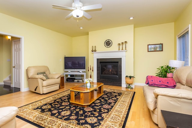 7009 Suncrest Dr, Saline, MI 48176 - living area with wood finished floors, a ceiling fan, a fireplace with flush hearth, stairs, and recessed lighting