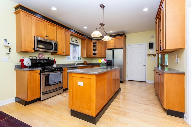 7009 Suncrest Dr, Saline, MI 48176 - kitchen with stainless steel appliances, dark countertops, light wood-style floors, a center island, and brown cabinetry
