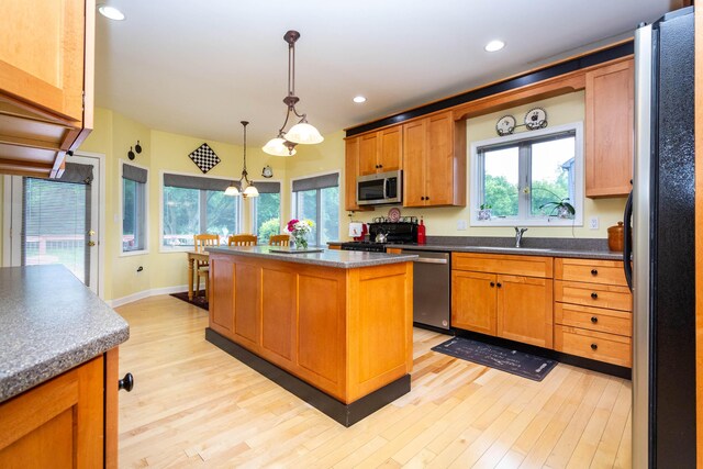7009 Suncrest Dr, Saline, MI 48176 - kitchen featuring appliances with stainless steel finishes, light wood-style floors, a center island, healthy amount of natural light, and recessed lighting