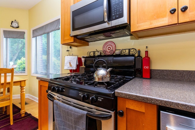 7009 Suncrest Dr, Saline, MI 48176 - kitchen with appliances with stainless steel finishes, wood finished floors, dark countertops, wine cooler, and baseboards
