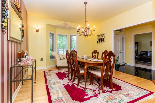 7009 Suncrest Dr, Saline, MI 48176 - dining space with a chandelier, light wood finished floors, and baseboards