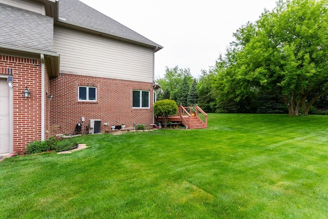 7009 Suncrest Dr, Saline, MI 48176 - view of green lawn with a wooden deck, central AC unit, and an attached garage