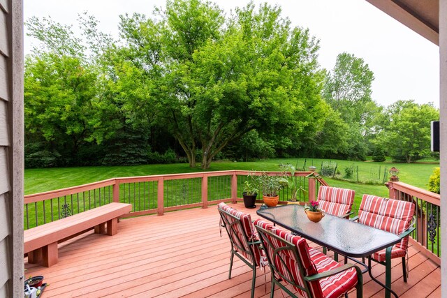7009 Suncrest Dr, Saline, MI 48176 - wooden terrace featuring a lawn, outdoor dining space, and view of wooded area