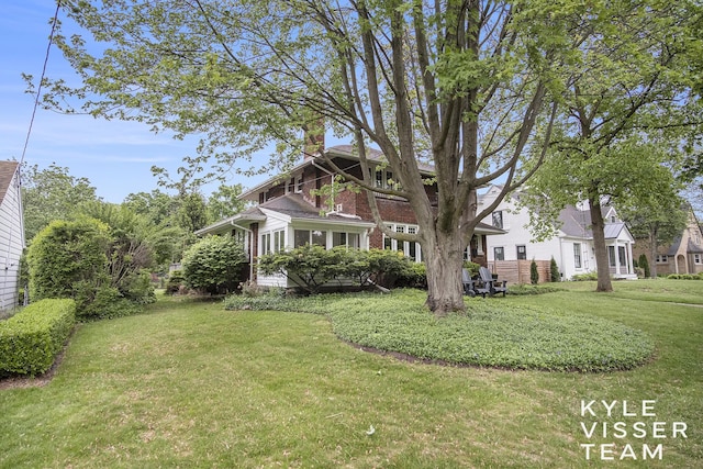 1058 Eastwood Ave SE, East Grand Rapids, MI 49506 - view of front of home with a chimney, a front yard, and brick siding