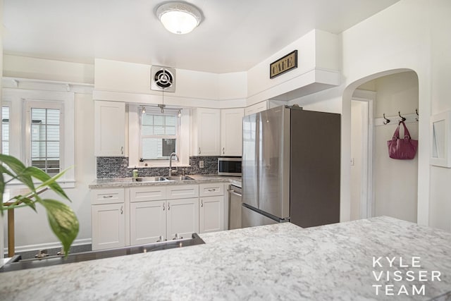 1058 Eastwood Ave SE, East Grand Rapids, MI 49506 - kitchen featuring stainless steel appliances, healthy amount of natural light, decorative backsplash, and white cabinetry